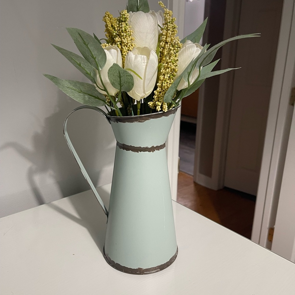 Cute metal watering can with faux flowers.